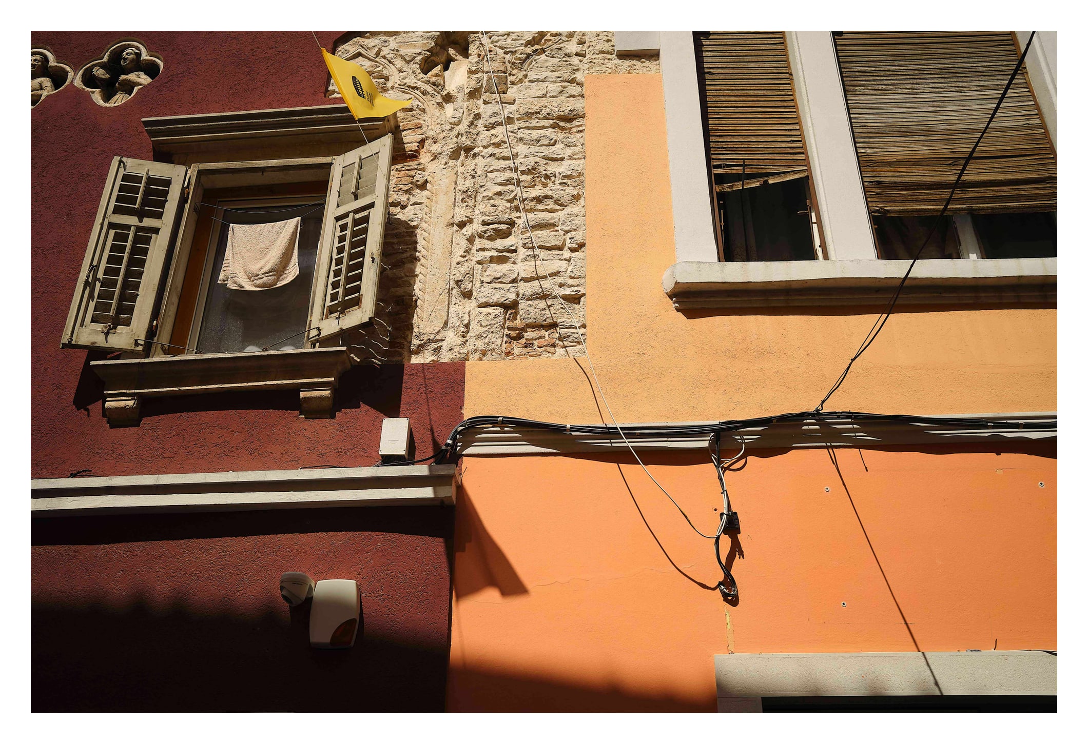 Zweifarbige Hauswand mit weißen Fensterrahmen